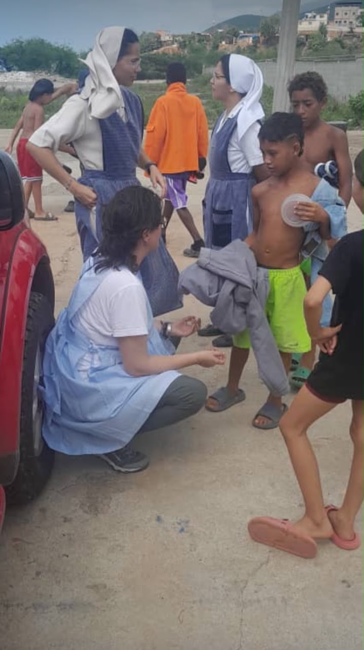 Una Hermana Adoratriz repartiendo comida